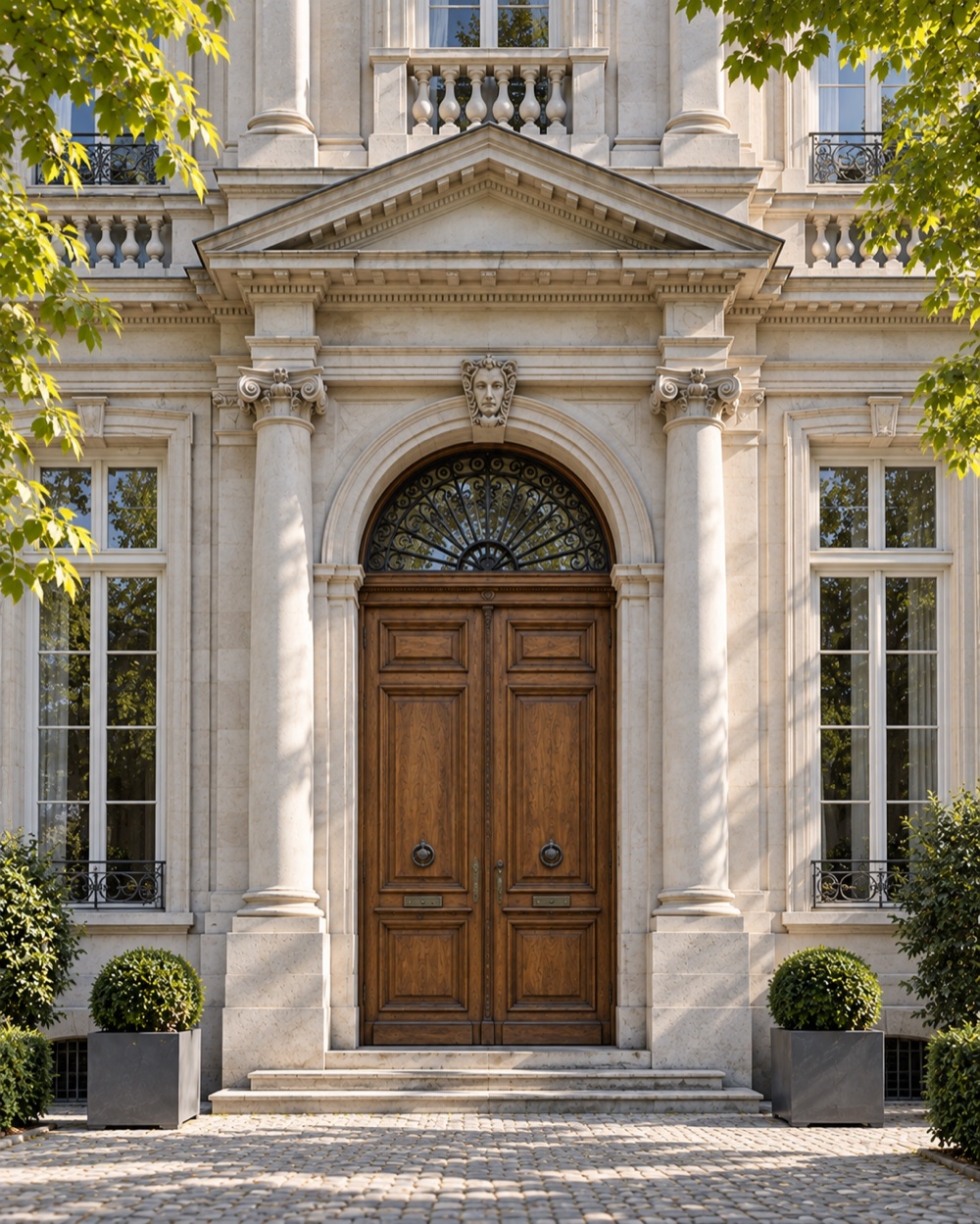 A light neoclassical facade with a monumental entrance and a closed wooden double door.