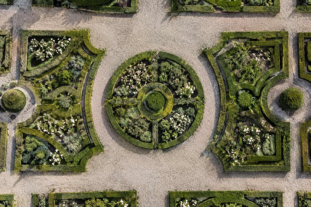 Geometric garden with low hedges and gravel paths, viewed from directly above